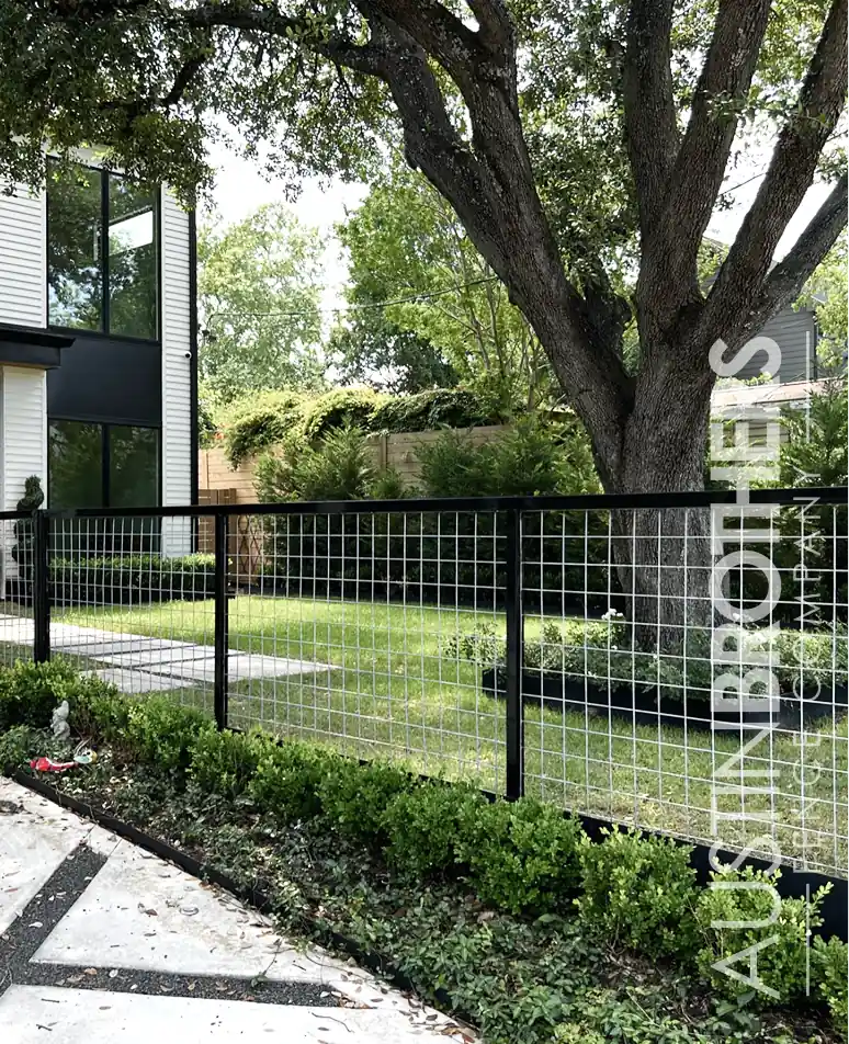Black bull panel fence with wire mesh around a front yard