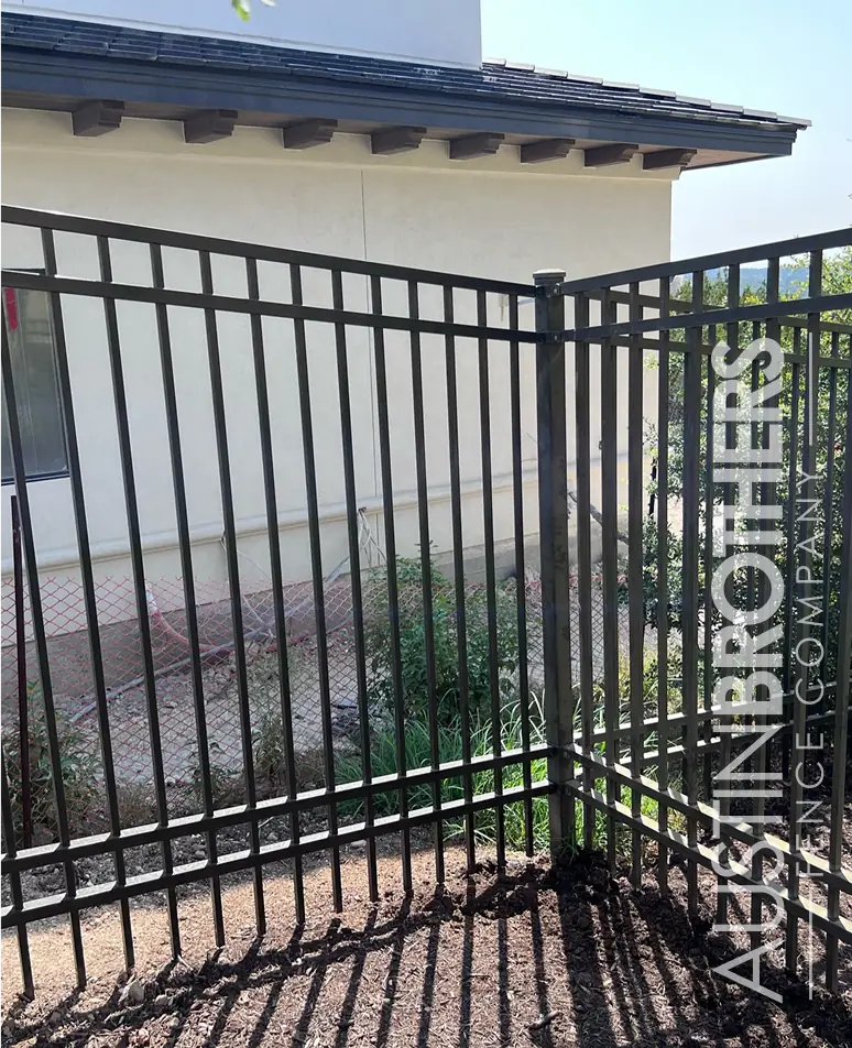 Black ornamental iron fence at a property corner