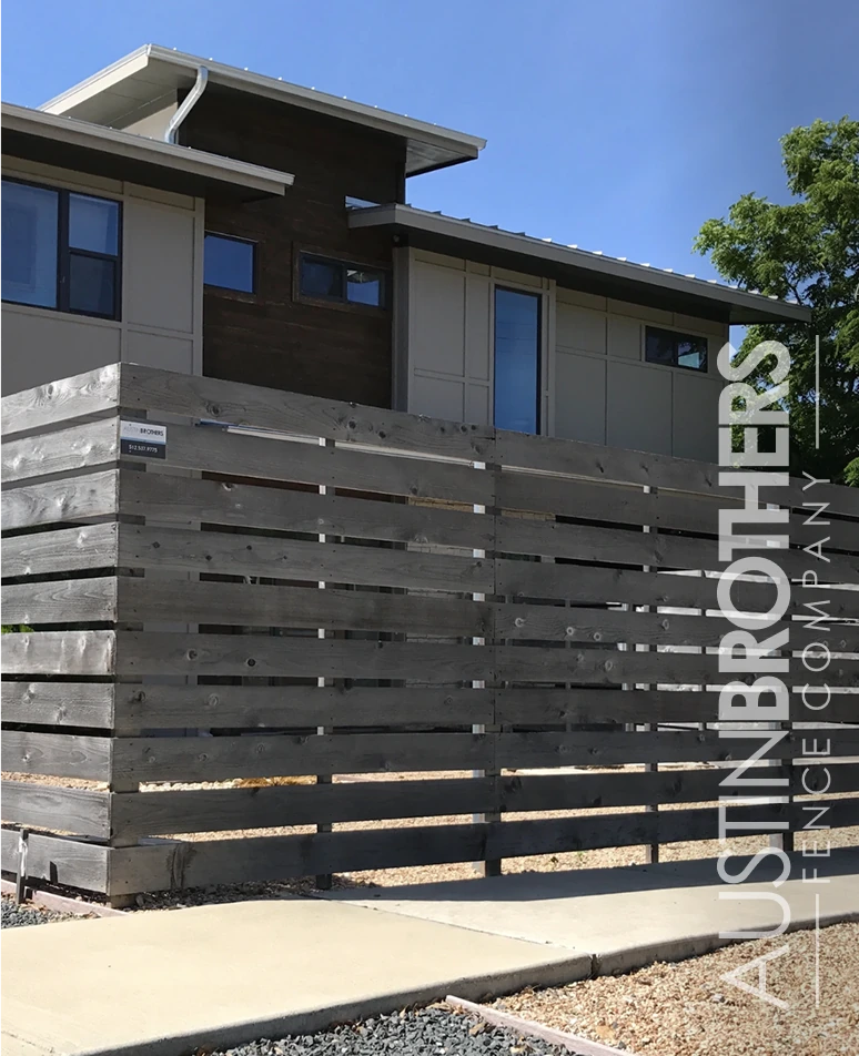 Gray stained horizontal fence beside a modern home