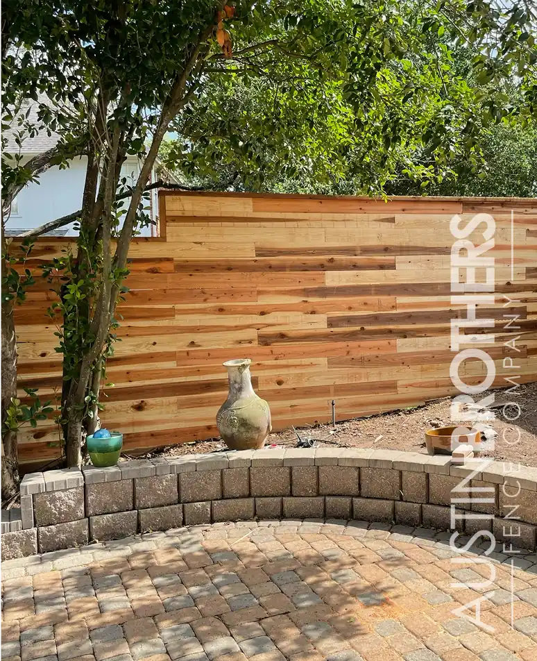 Horizontal cedar privacy fence above a stone patio